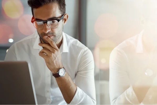 man looking pensively at laptop